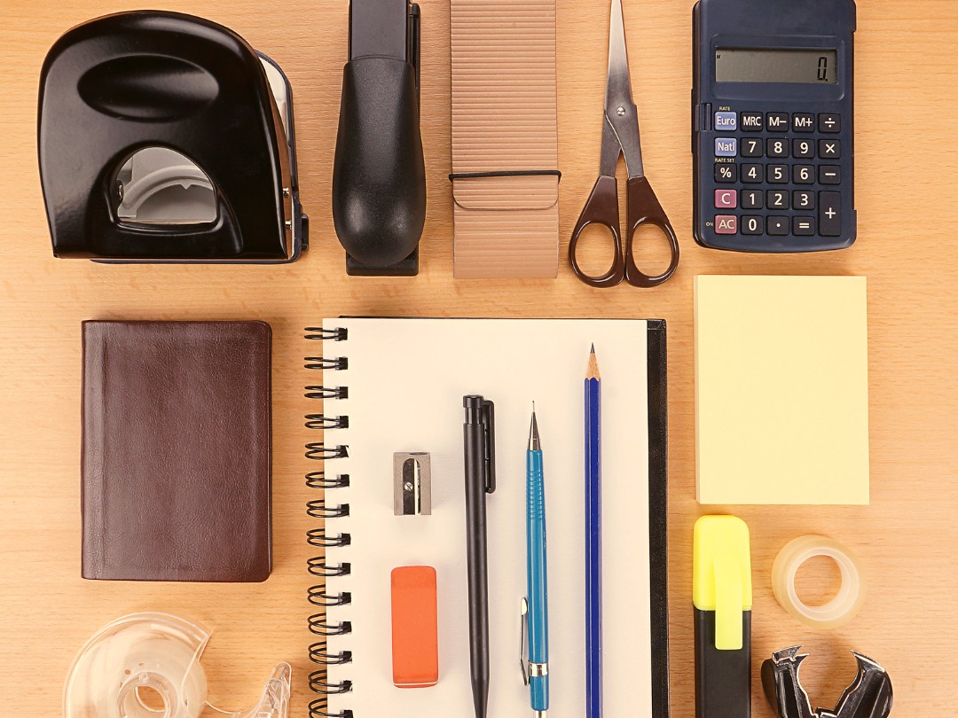 Office supplies including calculator, hole punch, scissors, and notebook